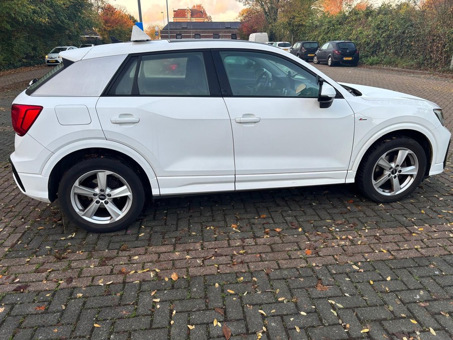 De witte Audi Q2-lesauto van Autorijschool Target, zijaanzicht